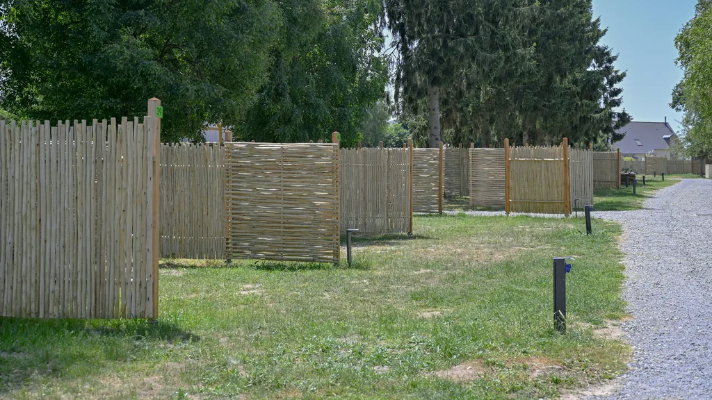 allee emplacements nus palissade camping Allée gravillonnée bordée de palissades tressées en châtaignier séparant les emplacements nus du camping
