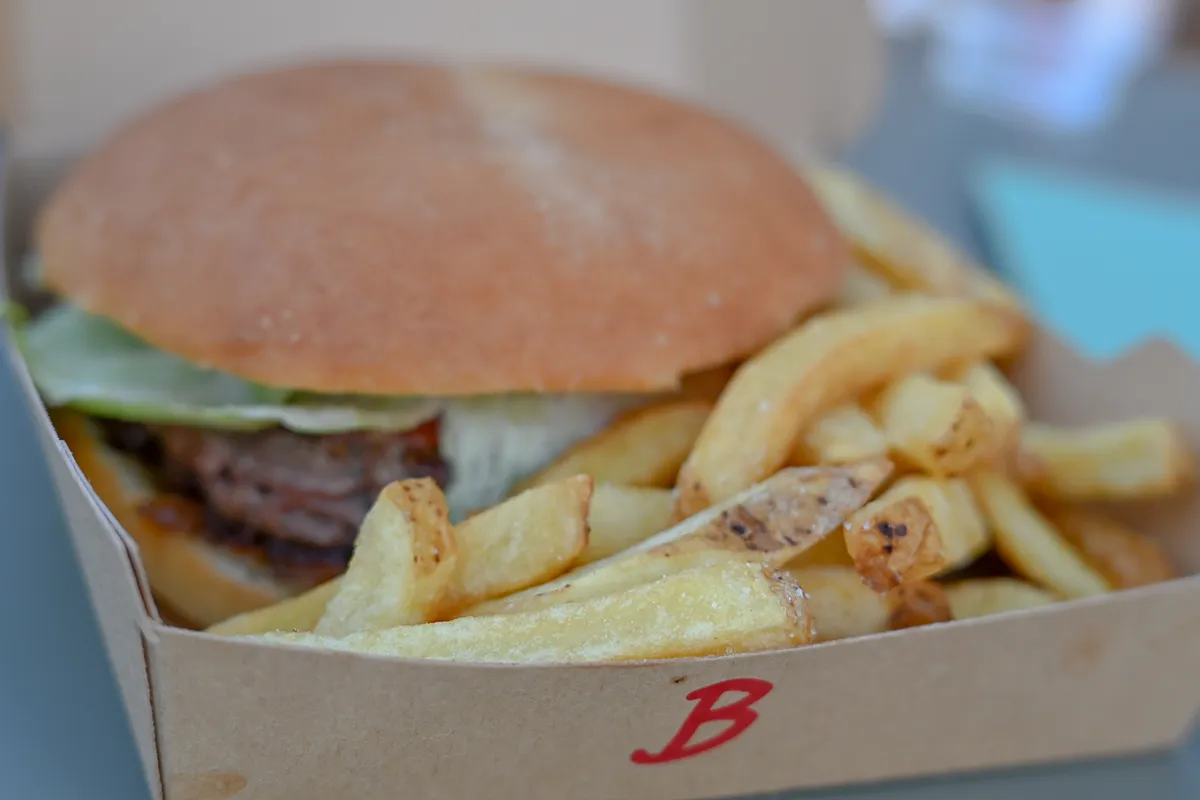 burger frites snack camping Burger et frites servis dans une barquette en carton au snack du camping