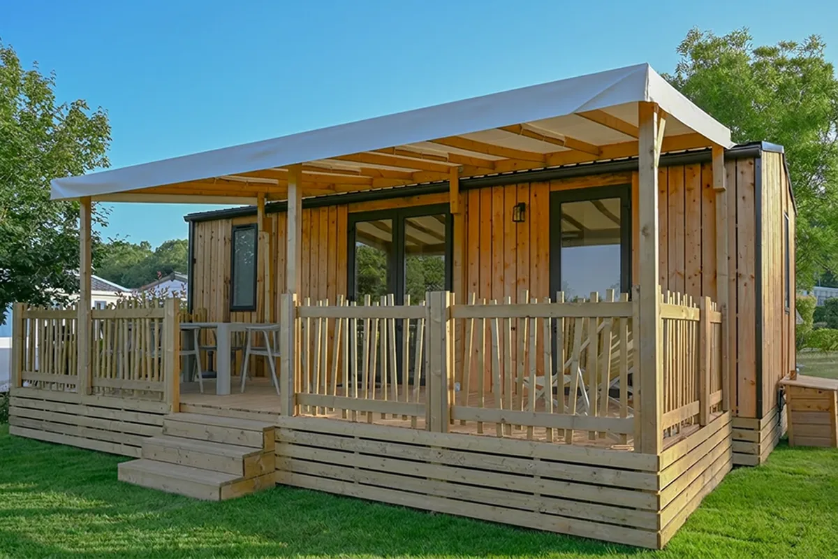 mobil home premium terrasse bois gazon Mobil-home gamme Premium à l'habillage bois avec grande terrasse couverte sur pelouse
