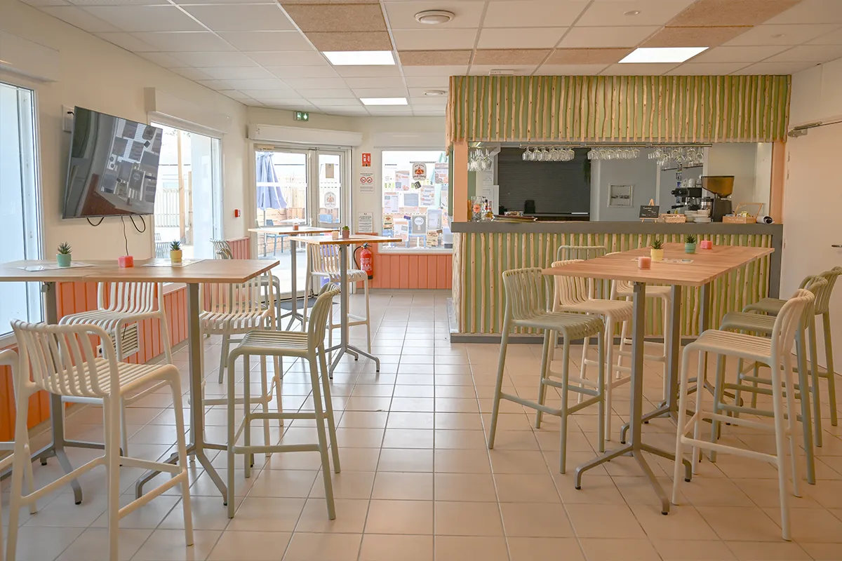 snack bar comptoir tables hautes Comptoir du snack-bar avec tables hautes, chaises et écran de télévision au mur
