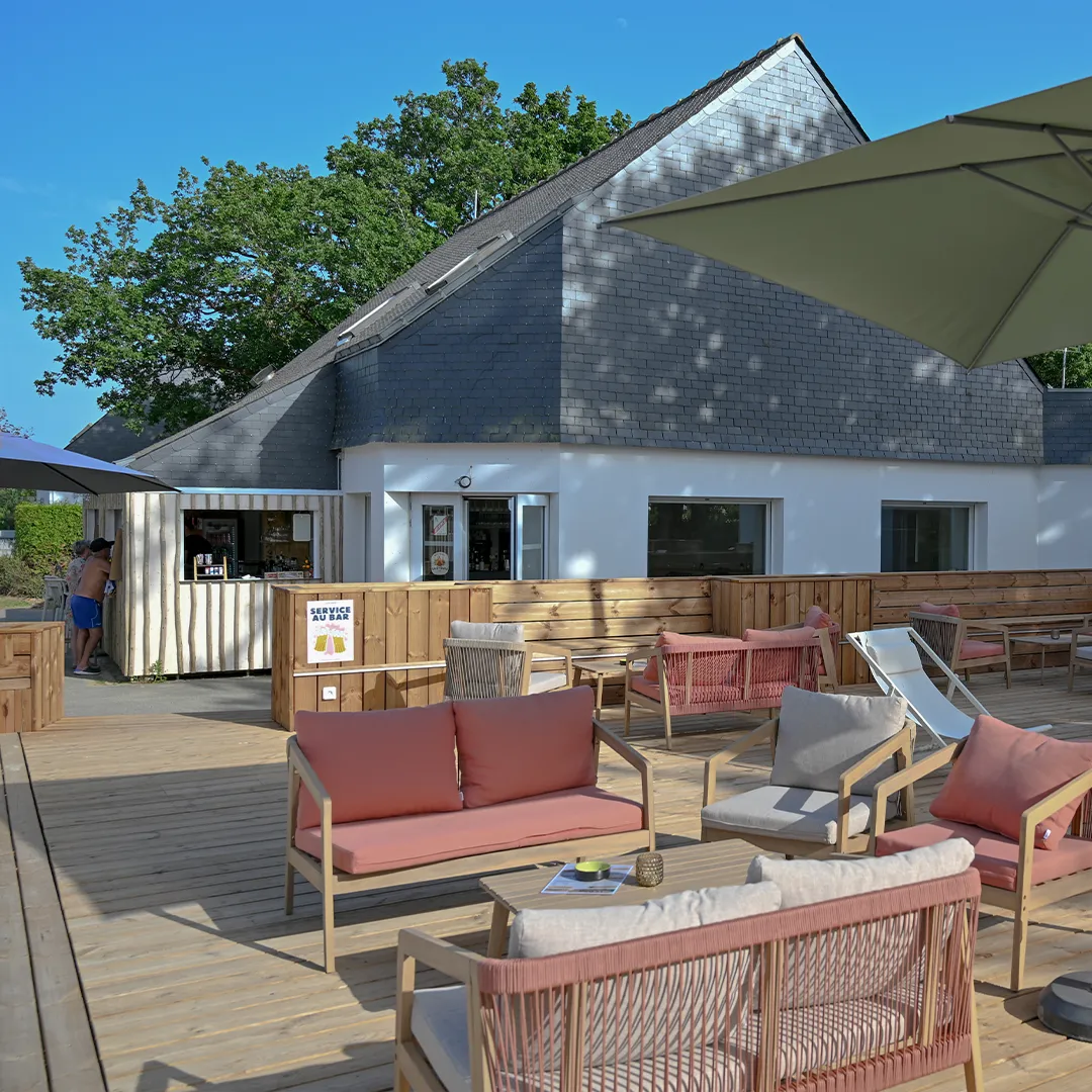 terrasse snack bar service camping Terrasse extérieure du snack avec service au bar, canapés et fauteuils roses