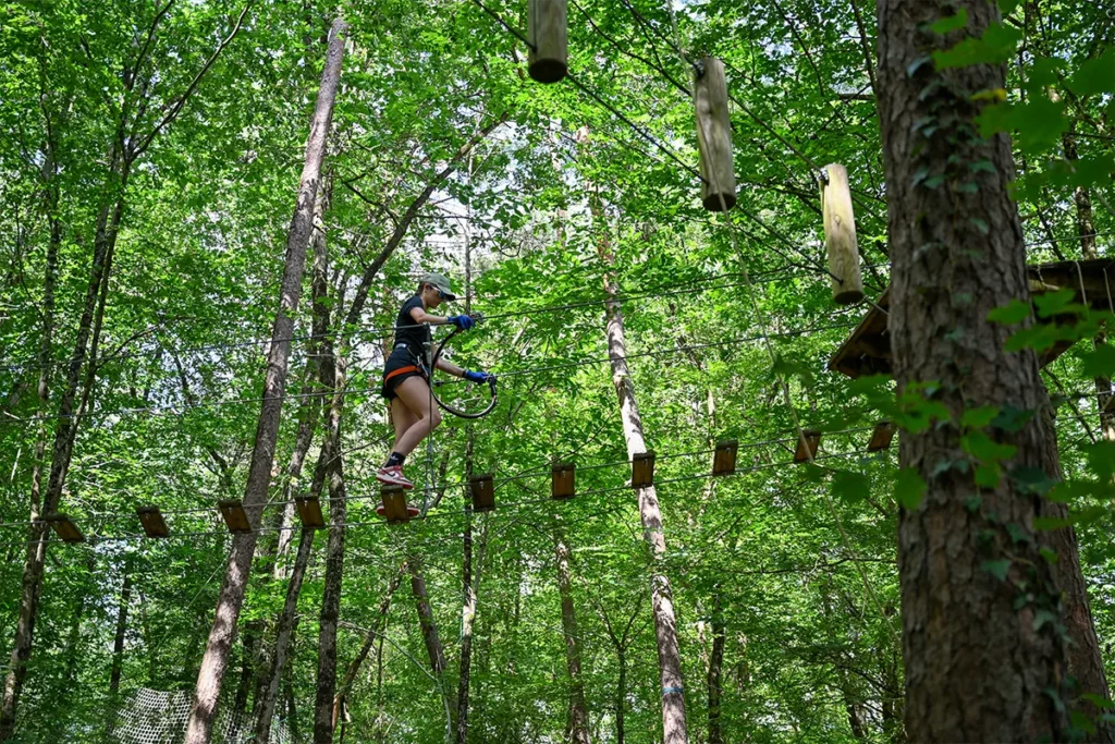 CDL Accro Lisa Suspendue à une tyrolienne d’un parcours d’accrobranche en forêt