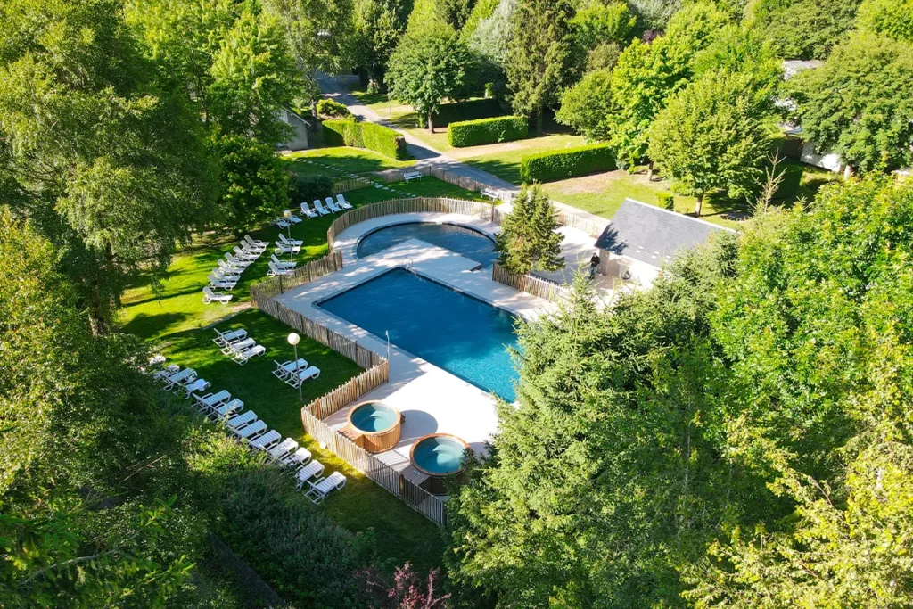 piscine drone large Vue aérienne de l’espace aquatique du camping Pradelongue au milieu des arbres