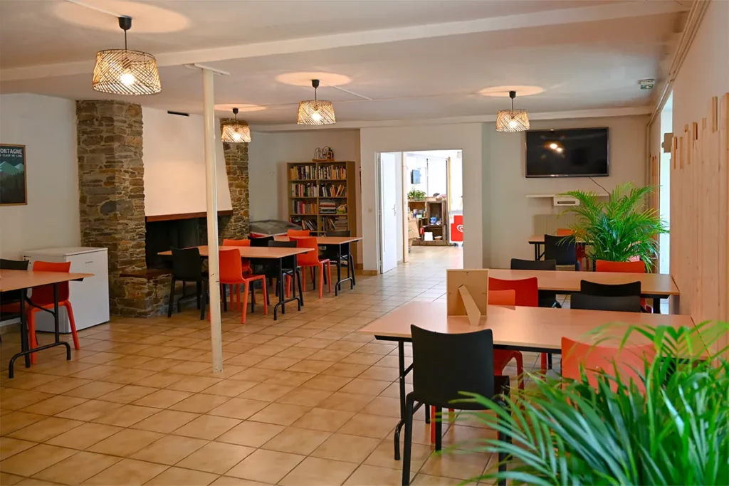salle polyvalente2 Salle polyvalente du camping Pradelongue avec tables et coin bibliothèque